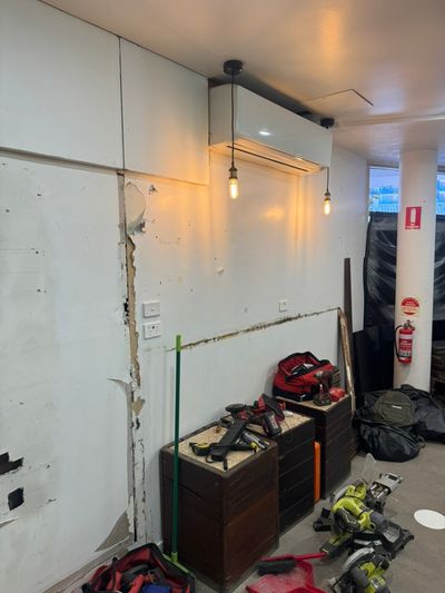 Wall-mounted split and pendant lights in the Good Eats seating room during fit-out