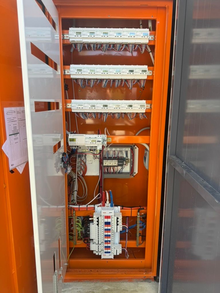 Orange lighting control cabinet at Marine Apartments with PE-cell contactors and distribution