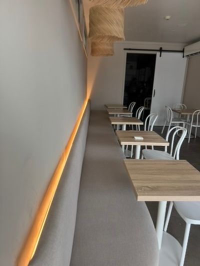 Finished Good Eats Mooloolaba banquette with a warm LED line and cafe tables
