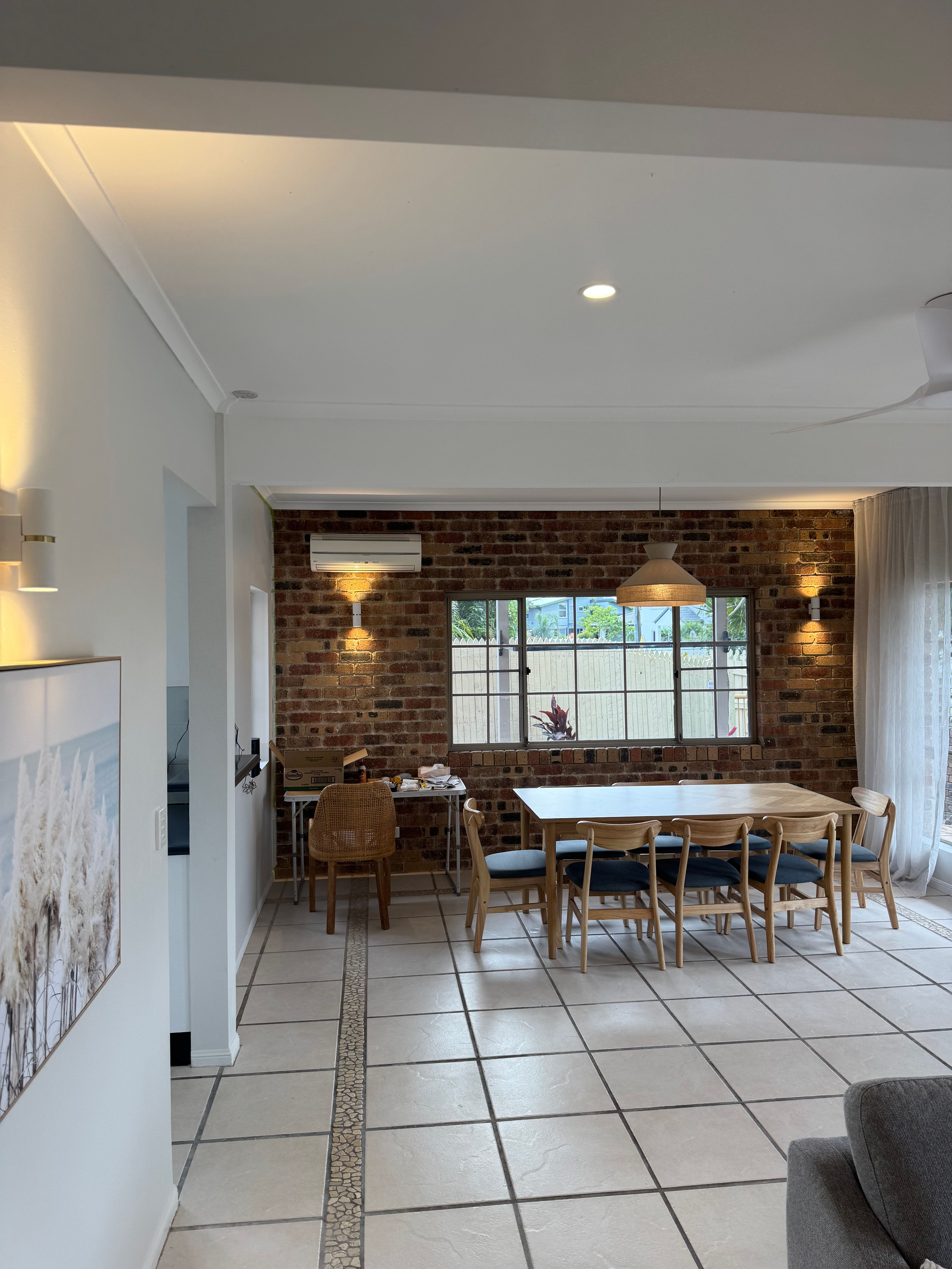 Dining area with brick walls, pendant and wall lighting