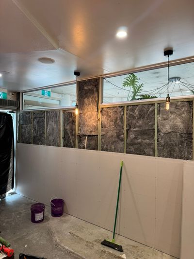 Pendant drops and a downlight over a half-sheeted wall during the Good Eats Mooloolaba seating fit-out