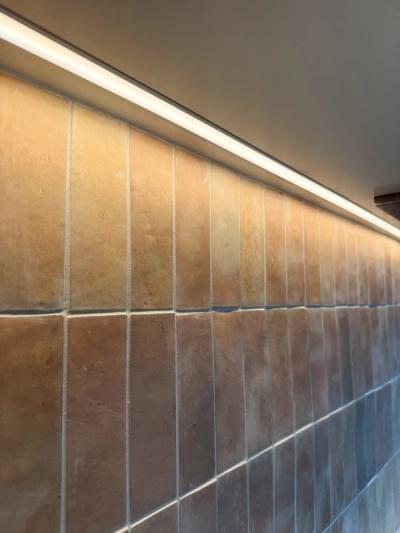 LED strip lighting washing light across a tiled kitchen splashback during the Tewantin renovation fit-off.