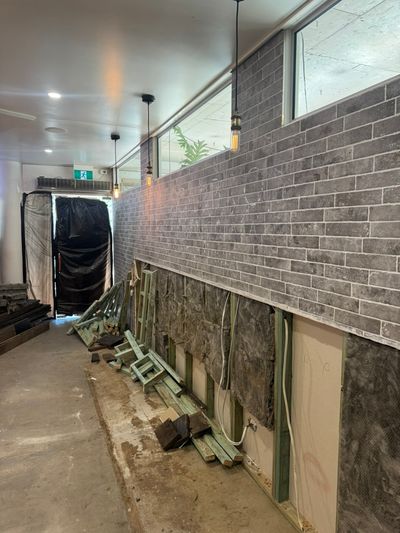 Pendant lighting along a brick-slip wall during the cafe renovation in Mooloolaba