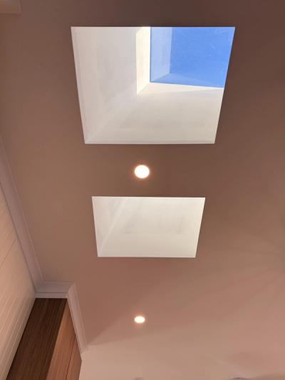 Ceiling downlights spaced with existing skylights to provide even task lighting in the renovated living area.