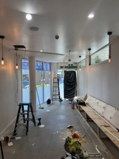 Long seating room with downlights and pendant drops during the Good Eats renovation