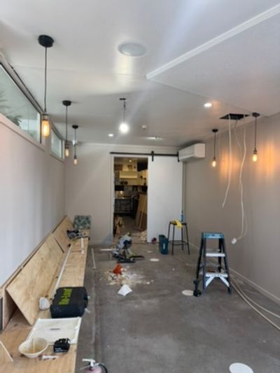 Seating room with pendant drops, downlights and a split before furniture went in