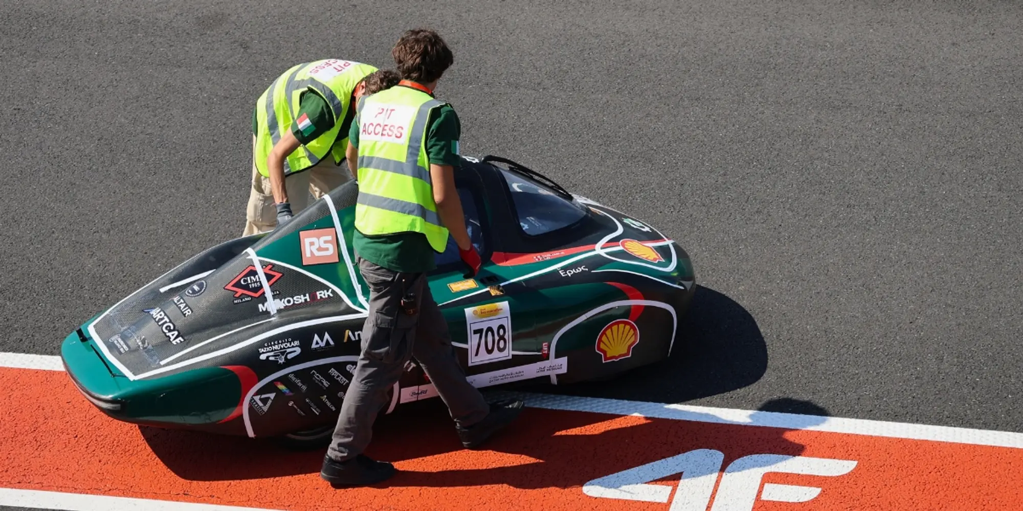Two team members checking experimental vehicle number 708 at the side of the track.