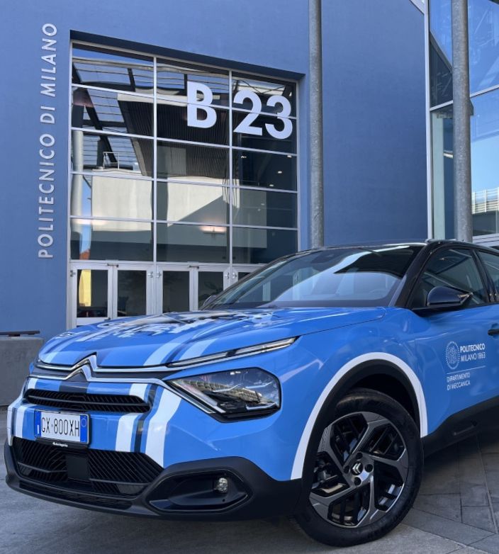 Auto di ricerca blu parcheggiata davanti all’ingresso dell’edificio B23 (DMEC).