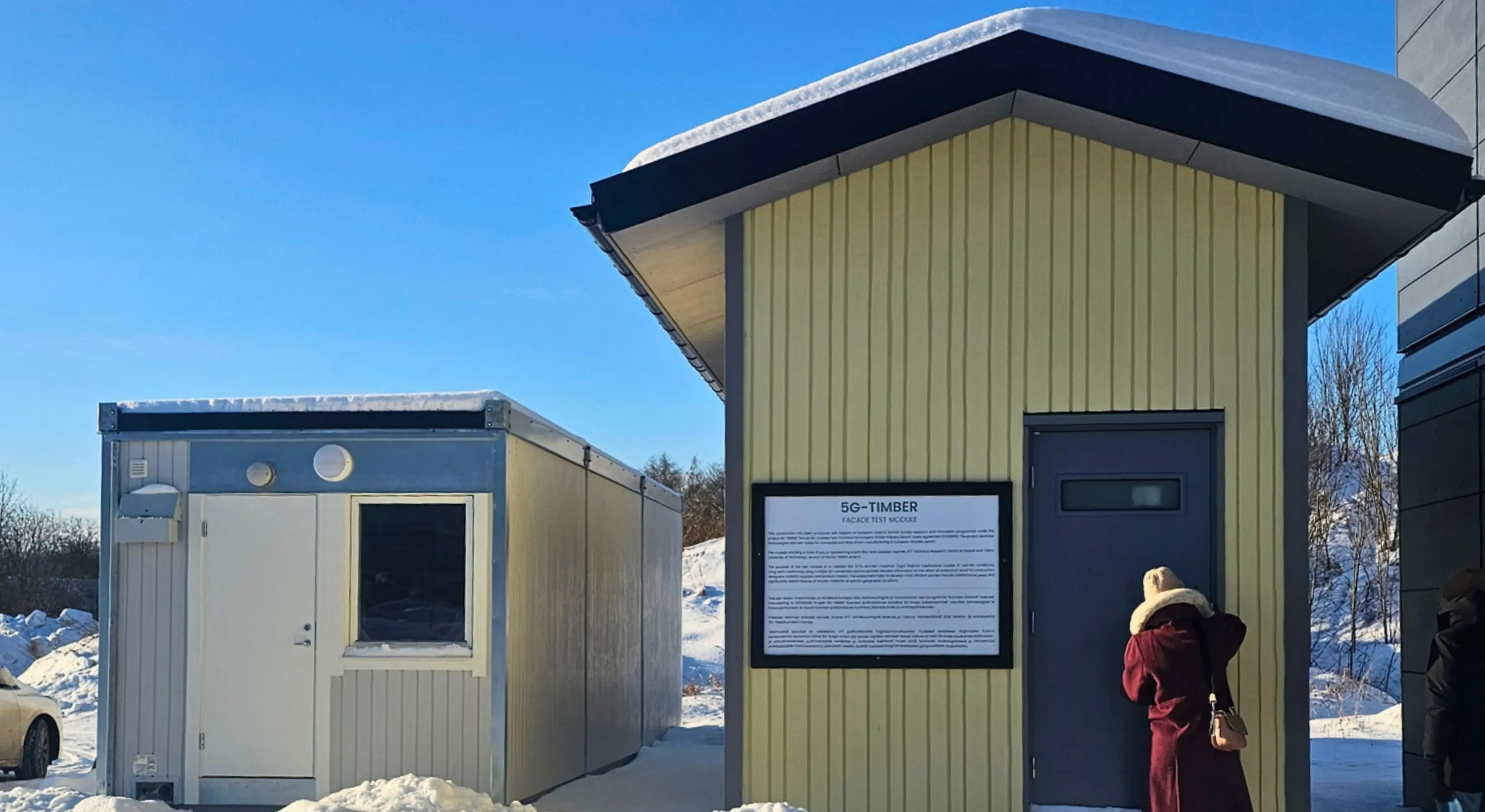 Experimental façade testing module in a snowy outdoor area.