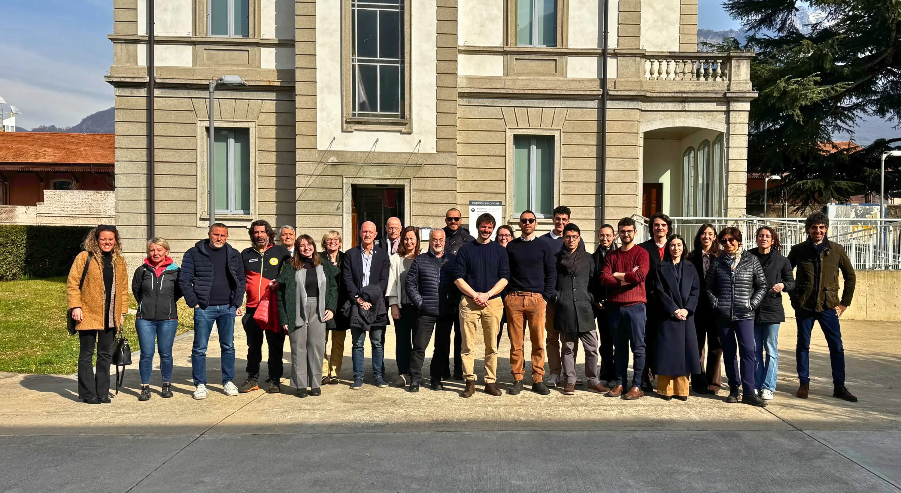 Group of people posing in front of a building.