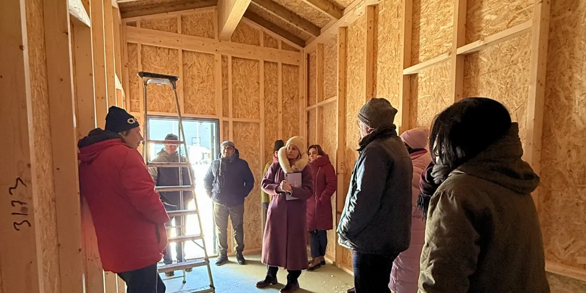 People inside a modular wooden structure during a 5G-TIMBER technical visit.