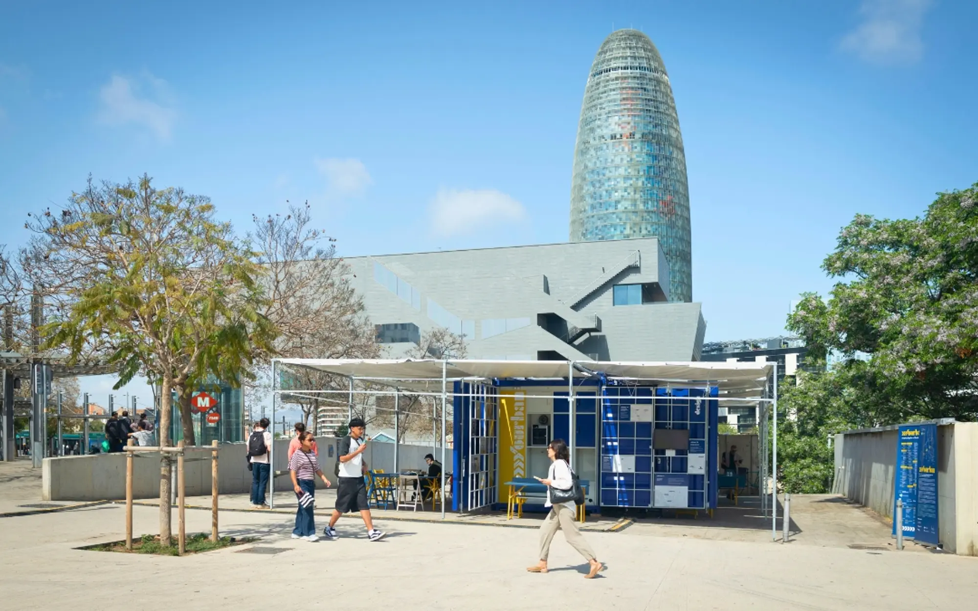 Temporary modular structure in an urban space with people and modern buildings in the background.