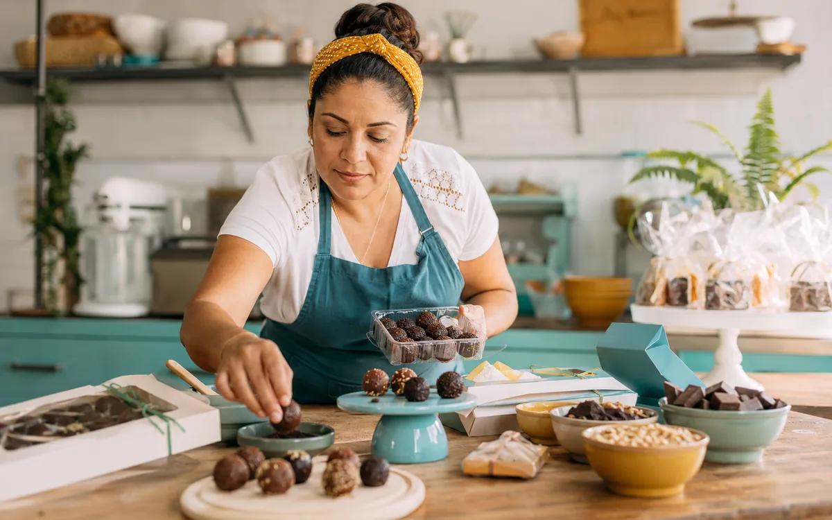 Empreendedora de confeitaria organiza produtos e embalagens para calcular o preço de venda