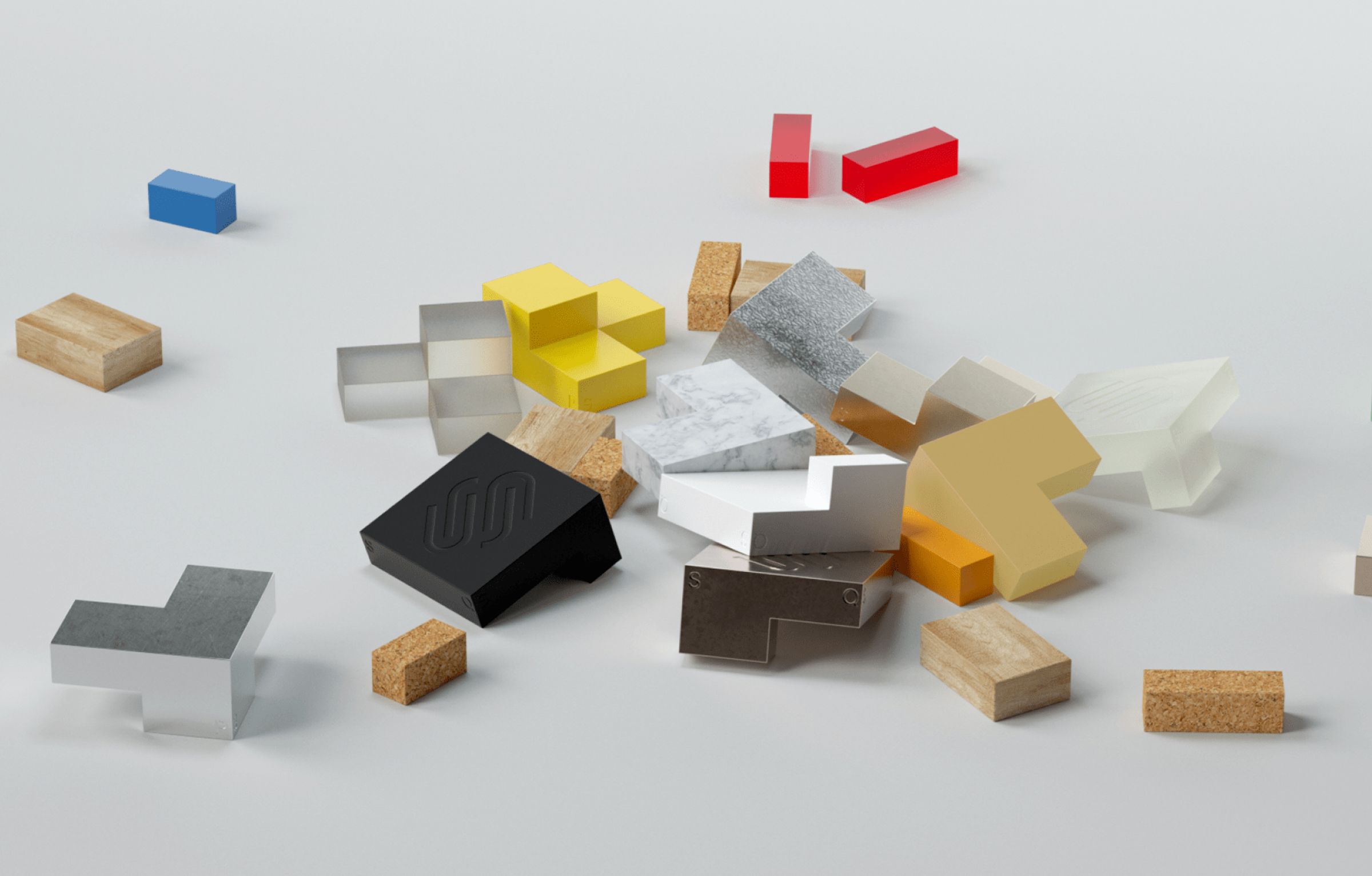 Colorful geometric shapes of different materials scattered on a gray surface.