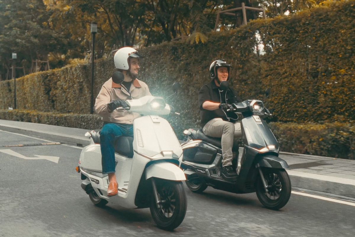 The driver driving EM E-Moto over the bridge