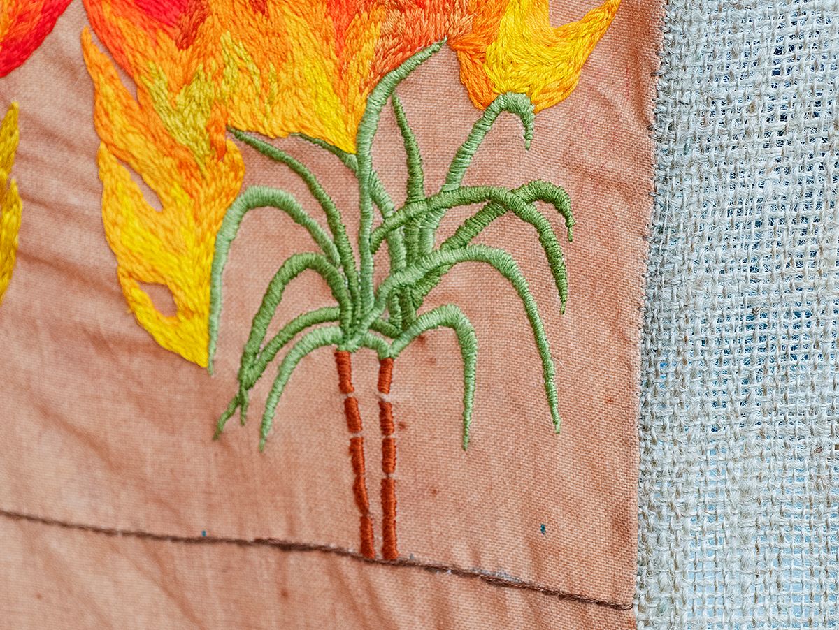Quishile Charan, Burning Ganna Khet (Burning Sugarcane Farm), 2021, 153cm by 152cm, close up of embroidery detail. Technique: hand dyed textile, embroidery thread, cotton, hessian sacks. Textile is naturally dyed with avocado seeds. Image taken by: Raymond Sagapolutele. 