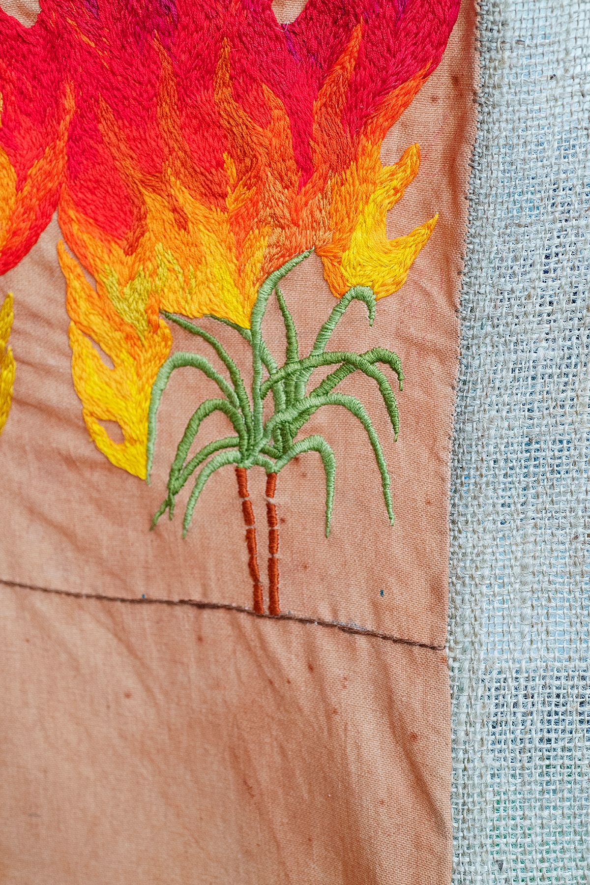 Quishile Charan, Burning Ganna Khet, 2021, cotton, embroidery thread, hessian sacks, natural dye: avocados, 153cm by 152cm. Close up of embroidery. Image taken by: Raymond Sagapolutele.