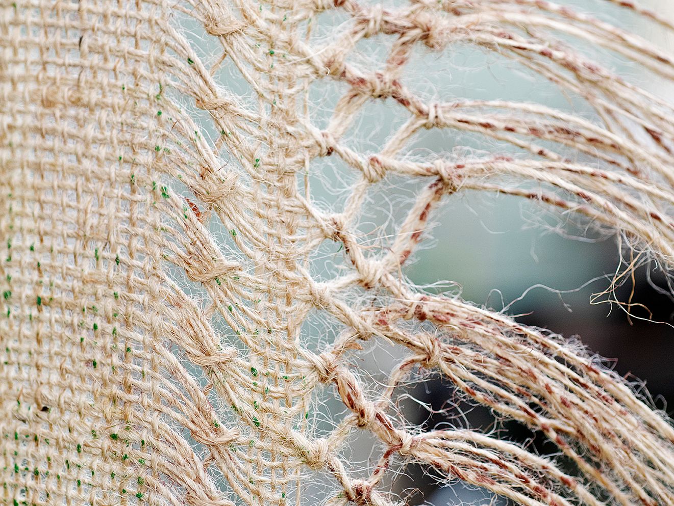Quishile Charan, Burning Ganna Khet (Burning Sugarcane Farm), 2021, 153cm by 152cm, close up of weaving detail. Technique: hand dyed textile, embroidery thread, cotton, hessian sacks. Textile is naturally dyed with avocado seeds. Image taken by: Raymond Sagapolutele. 