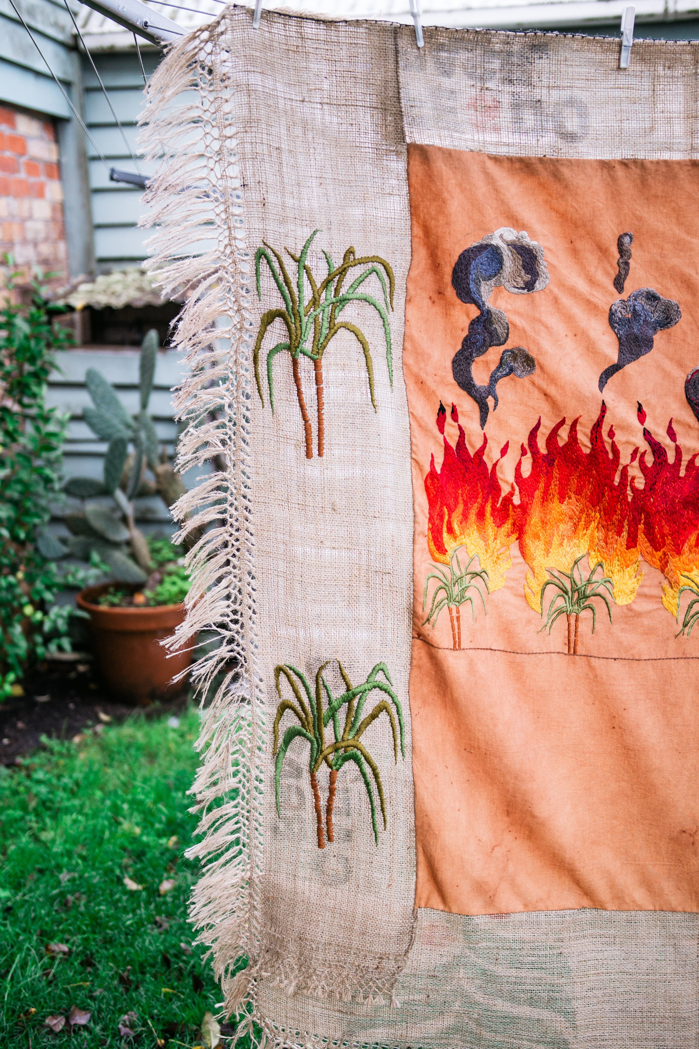 Quishile Charan, Burning Ganna Khet (Burning Sugarcane Farm), 2021, 153cm by 152cm. Technique: hand dyed textile, embroidery thread, cotton, hessian sacks. Textile is naturally dyed with avocado seeds. Image by Matavai Taulangau.