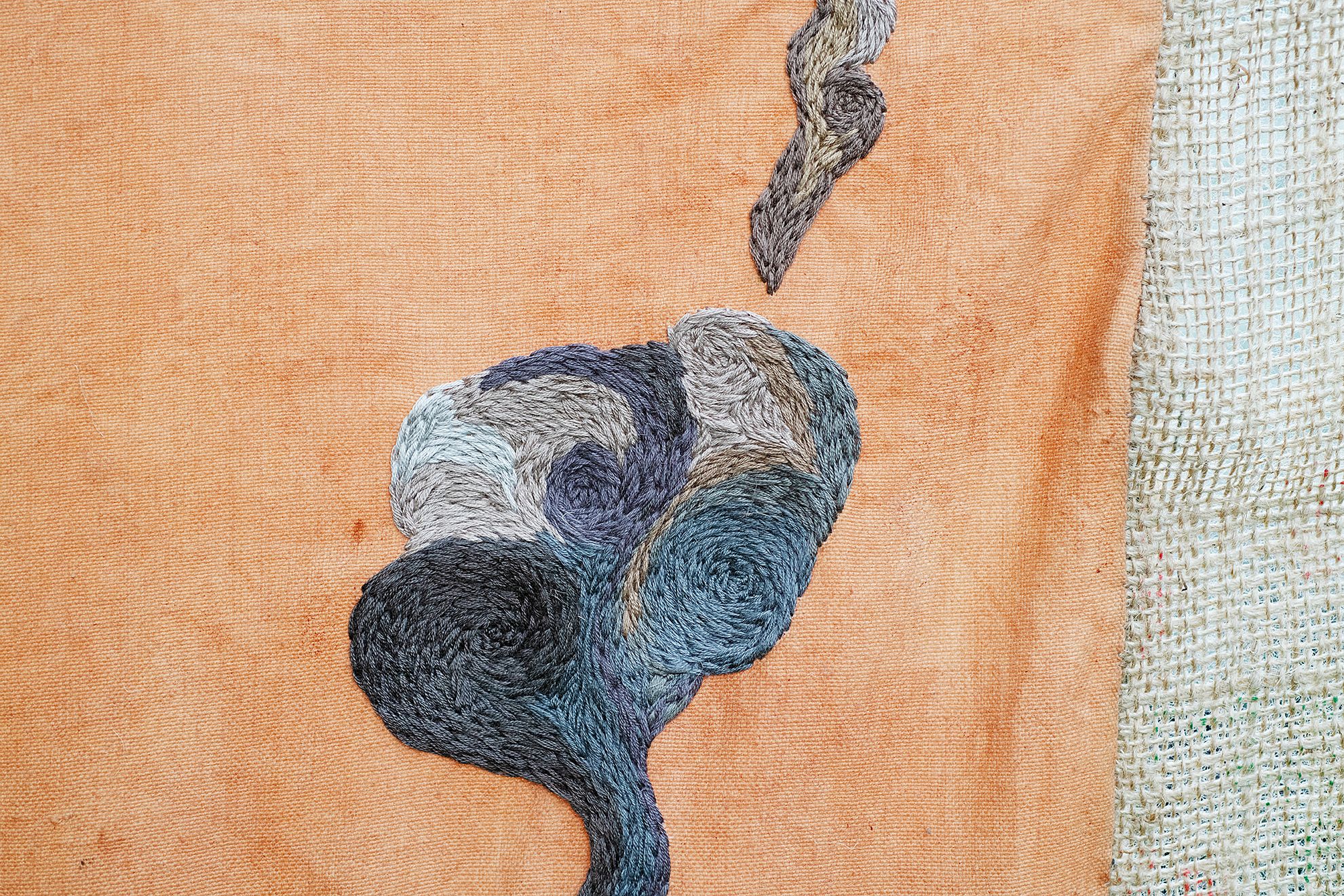 Quishile Charan, Burning Ganna Khet (Burning Sugarcane Farm), 2021, 153cm by 152cm, close up of embroidery detail. Technique: hand dyed textile, embroidery thread, cotton, hessian sacks. Textile is naturally dyed with avocado seeds. Image taken by: Raymond Sagapolutele. 