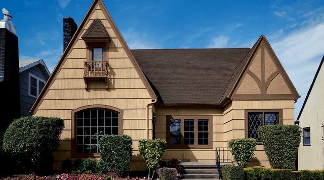 Tudor-style cottage in a warm straw yellow with a brown roof, from Sherwin-Williams’ exterior color gallery