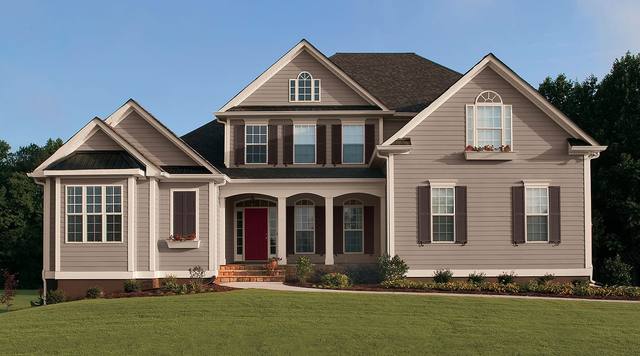 Traditional two-story home in warm neutral siding with dark shutters and a red front door, from Sherwin-Williams’ exterior color gallery