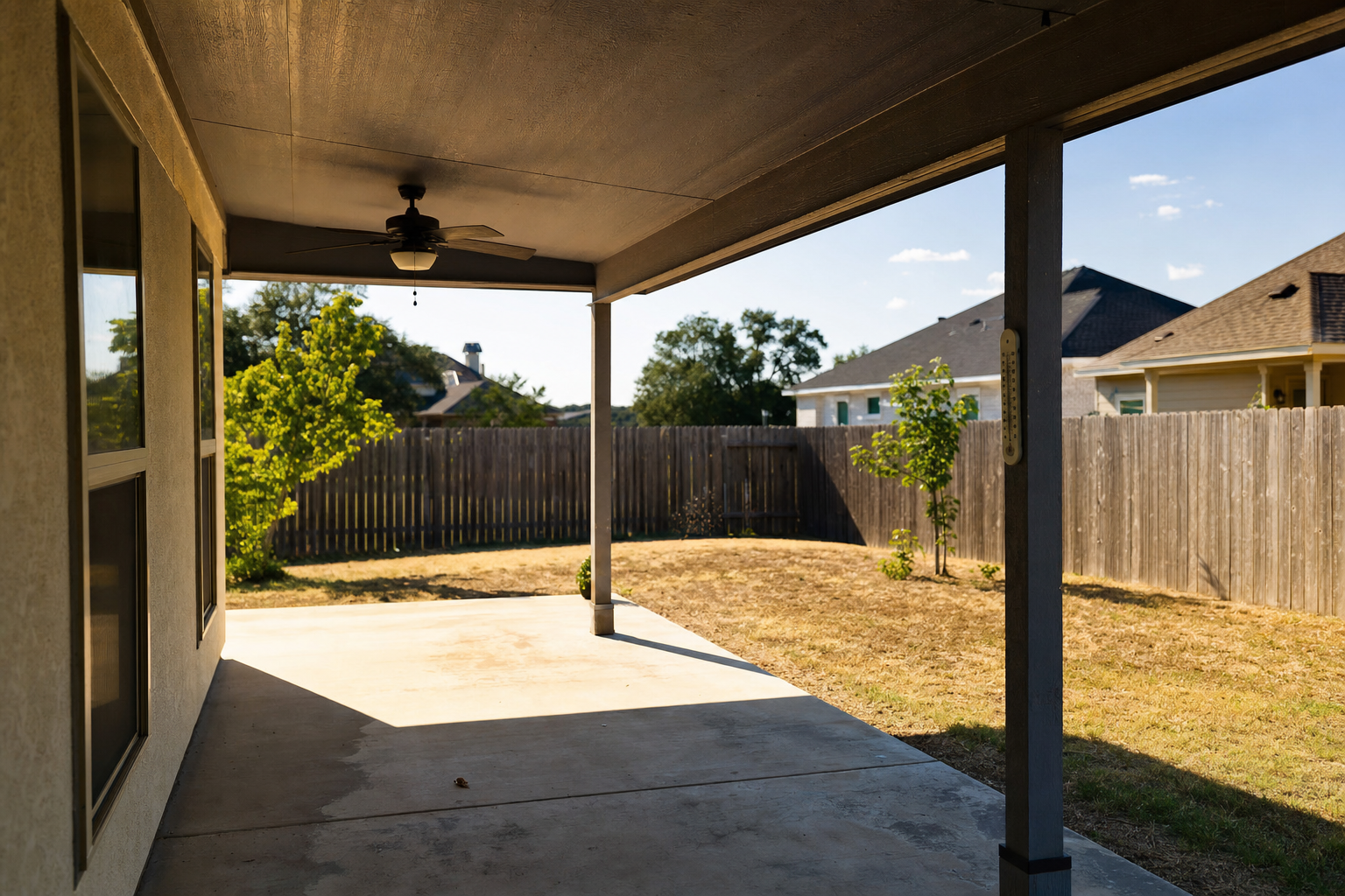 Empty covered Austin patio in July heat with heat haze and a thermometer over 100 degrees