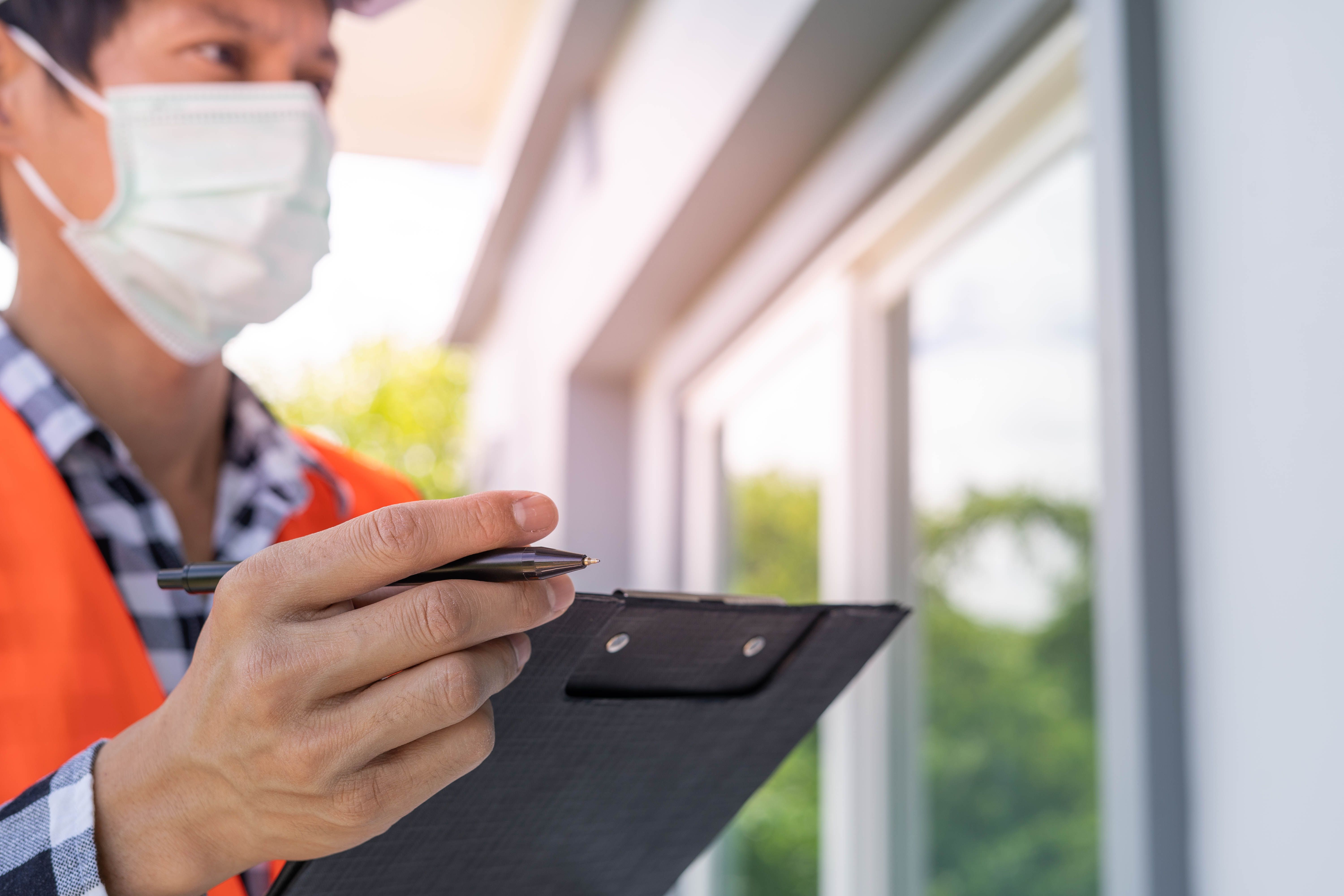 Real estate inspector checking window quality on a residential home exterior