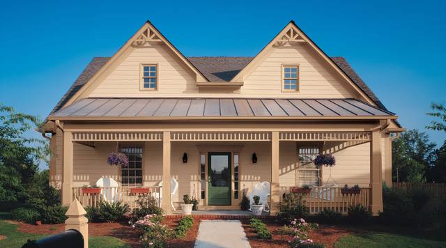 Farmhouse in pale tan lap siding with a standing-seam metal porch roof and a green front door, from Sherwin-Williams’ exterior color gallery