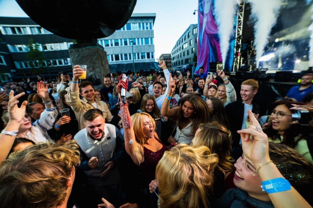 Nærbilde av en folkemengde som koser seg med en artist midt i.