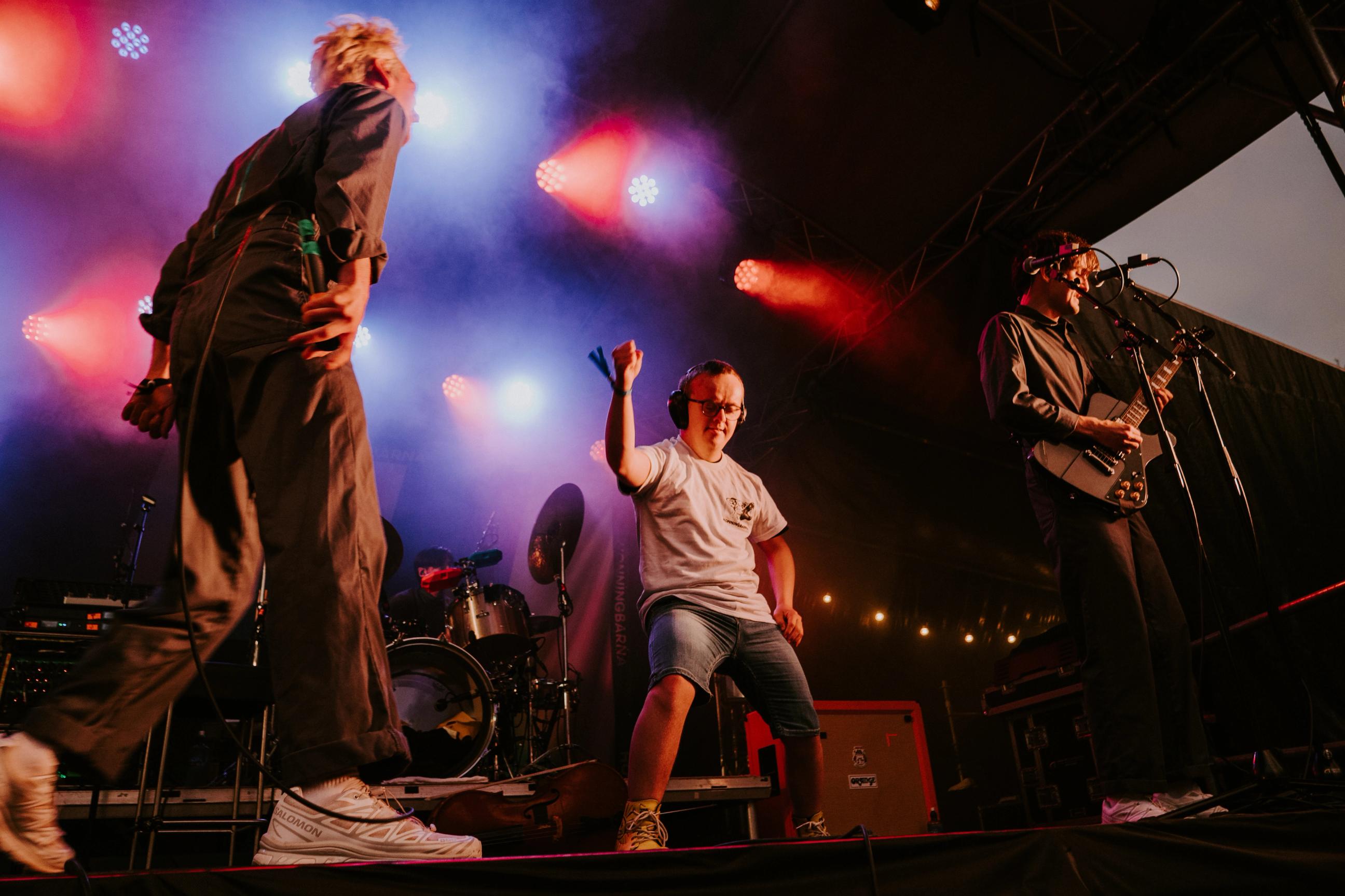 En publikummer står på scenen med bandet og danser
