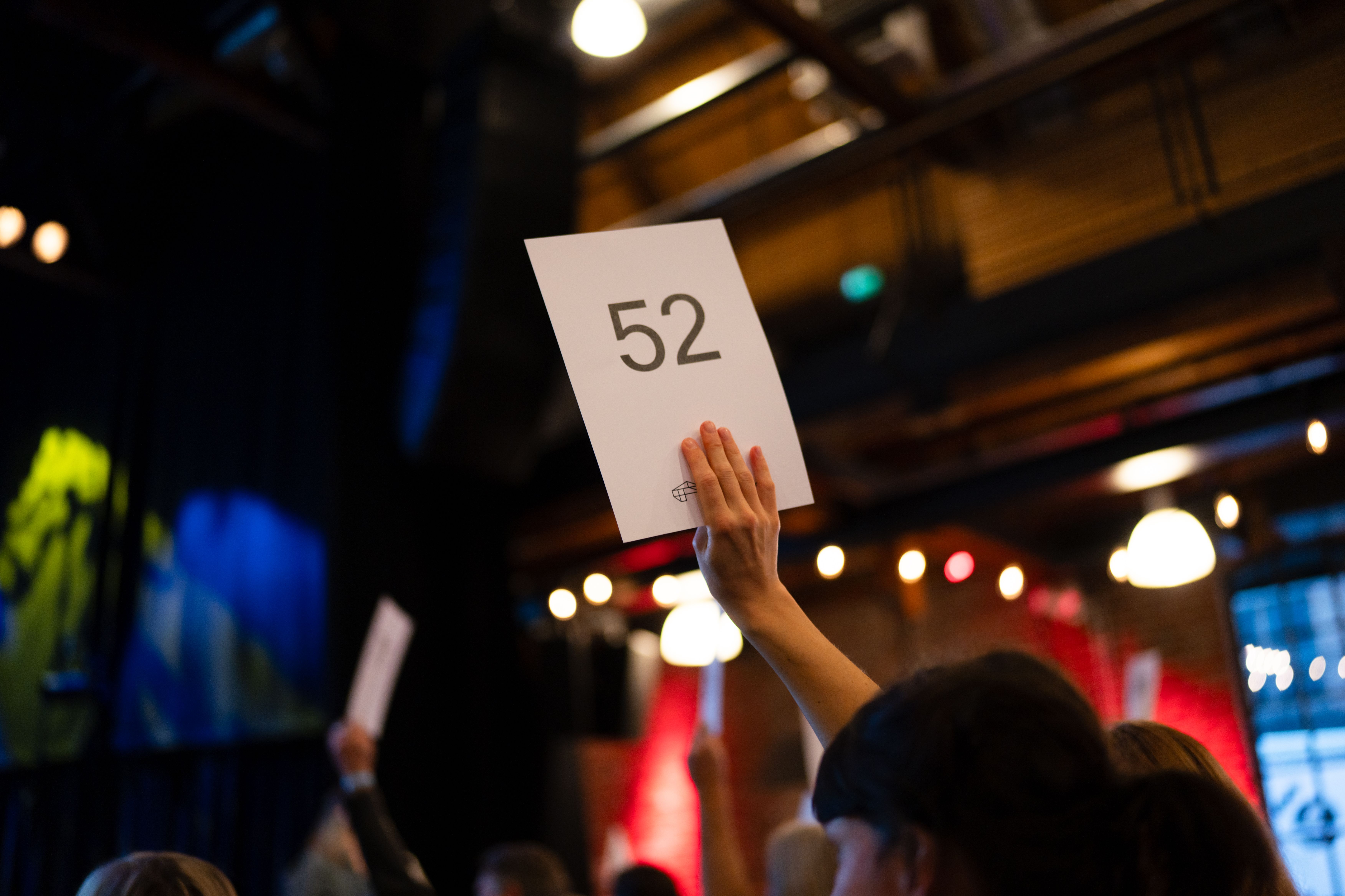 En stemmeseddel med tallet 52 holdes i lufta.