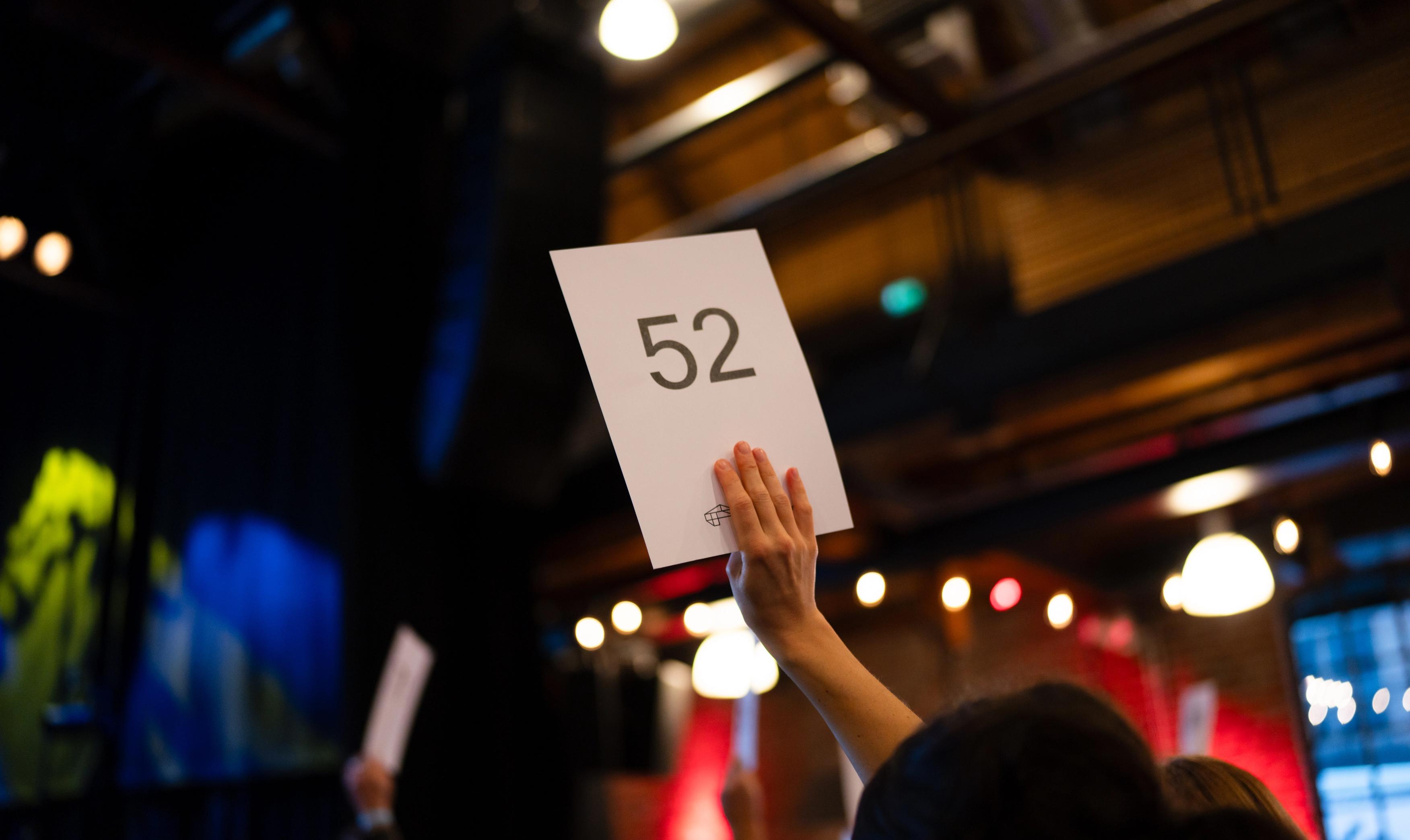 En stemmeseddel med tallet 52 holdes i lufta.