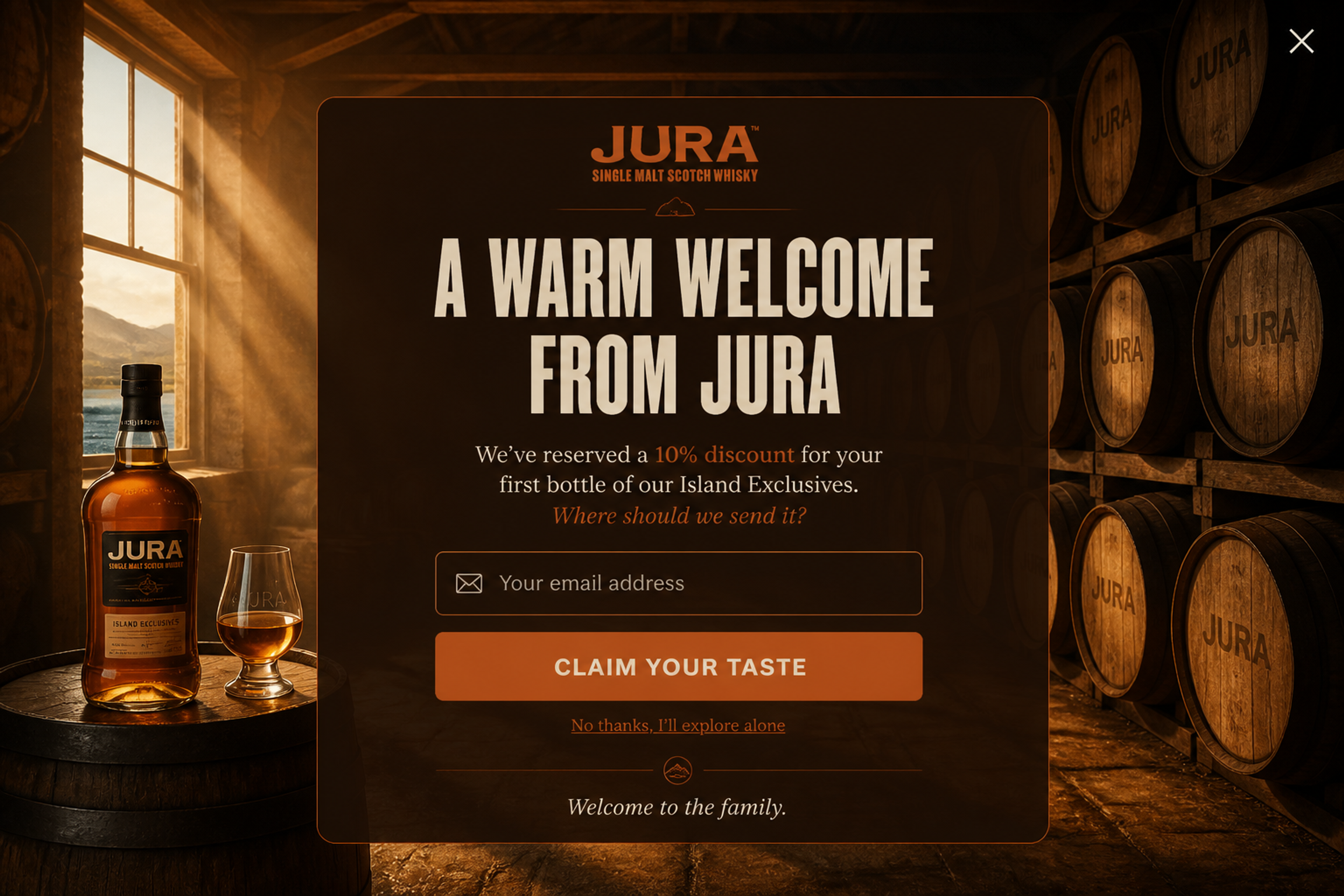 Fullscreen whisky welcome popup with the headline "A warm welcome from Jura" over a coastal photo