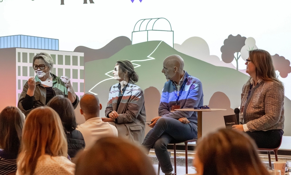 Fire personer i panelsamtale på en scene