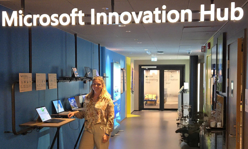 Person står i en Microsoft Innovation Hub med en lap top.