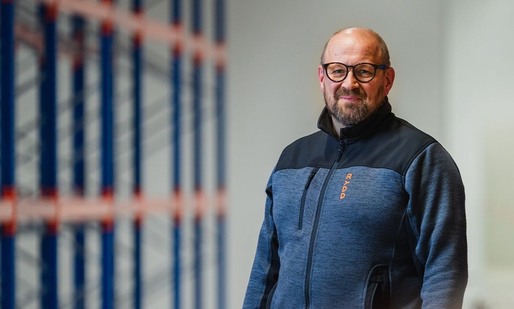 Mann med briller og fleecejakke i en lagerhall