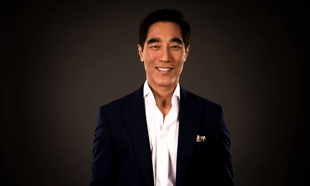 En mann i hvit skjorte og sort dressjakke