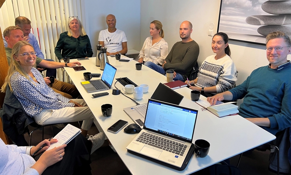 10 personer samlet rundt et bord med pc
