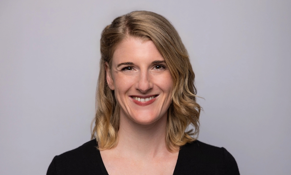 Kvinne smiler til kamera.