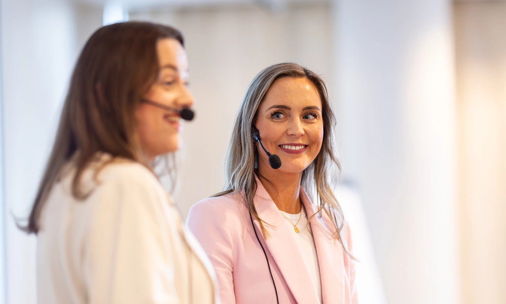 To kvinner i næringslivet som holder presentasjon.