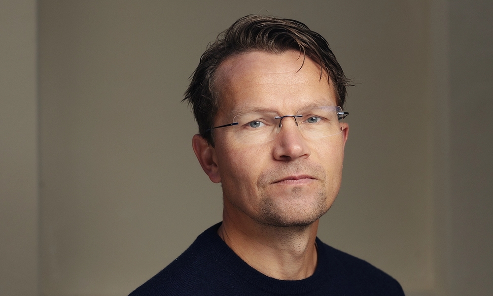 Mann med briller og mørkeblå genser