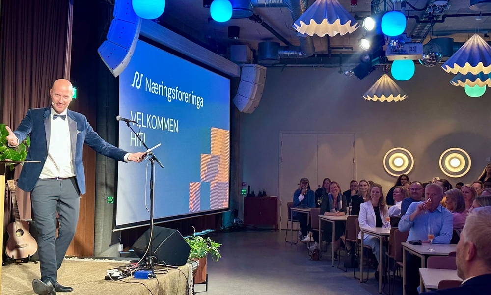 Mann i dress på scena og publikum