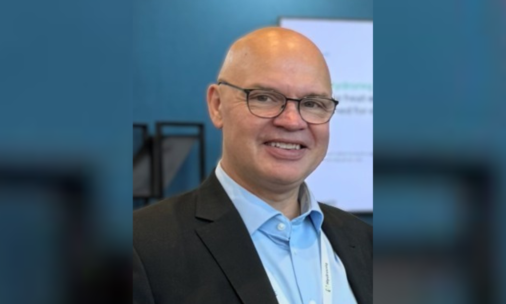 Mann med briller, blå skjorte og sort dressjakke