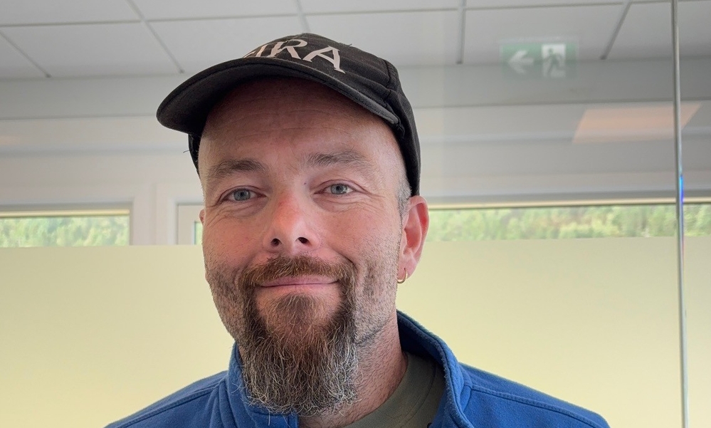 Mann med caps og blå glidelåsjakke