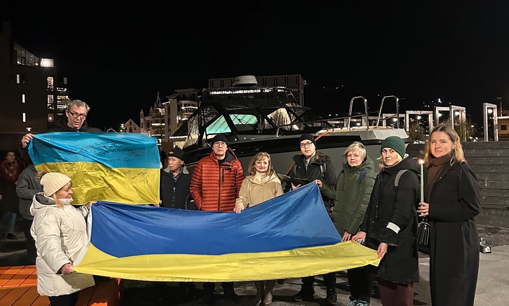 Personer holder et stort ukrainsk flagg