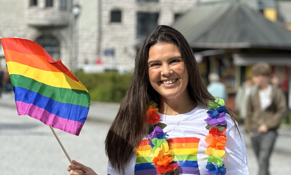 Kvinne som smiler med prideflagg i hånda