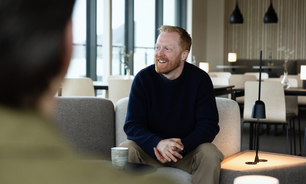 Mann sitter i en sofa i en kantine
