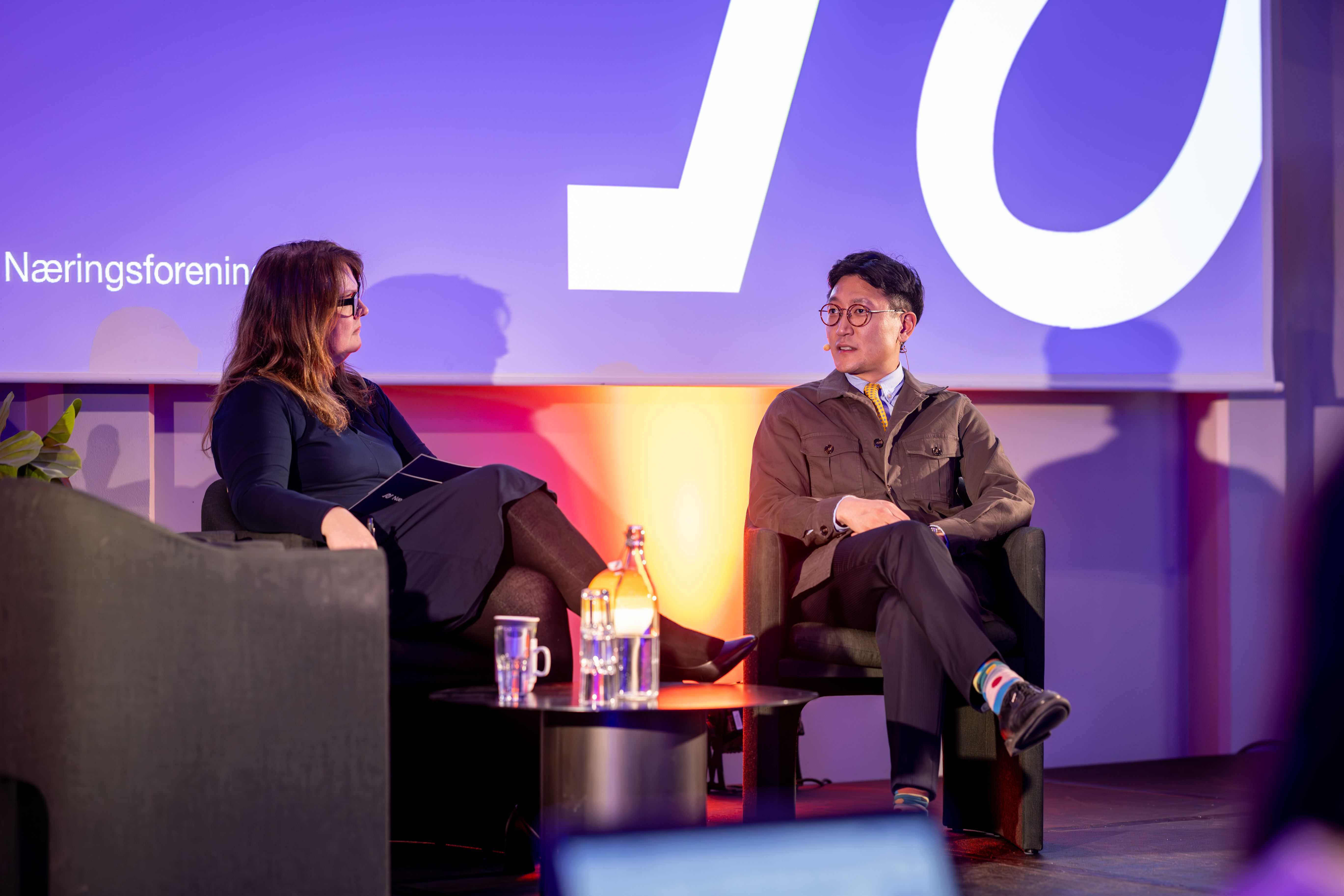 To personer i sofaprat på en scene