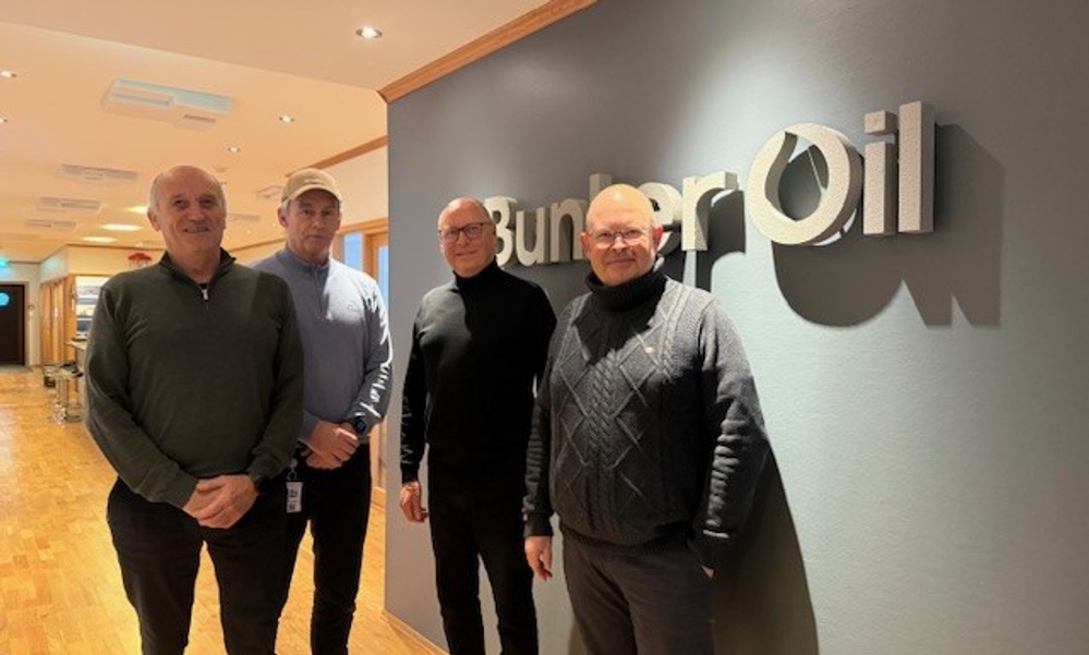 Fire menn foran grå vegg med Bunker Oil-logo